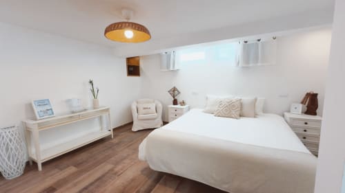 Suíte Nascer do Sol da Vila Vale Guest House em Charneca da Caparica com cama de casal, móveis creme, pisos em madeira e iluminação natural