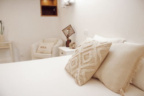Quarto Sunrise Suite da Vila Vale Guest House com cama, almofadas decorativas, poltrona e decoração minimalista em Charneca da