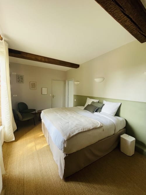 Chambre spacieuse à la Maison Nolette avec lit queen-size, tête de lit verte, poutres apparentes et vue sur le jardin à Noyelles sur Mer