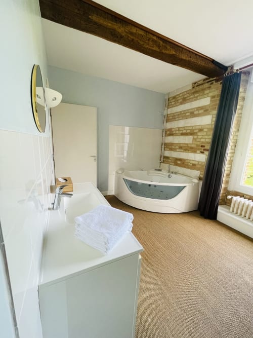 Salle de bain spa moderne avec baignoire balnéo, lavabo et douche à la Maison Nolette B&B à Noyelles sur Mer, France