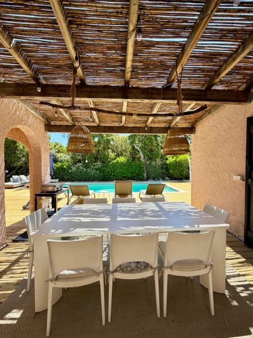 Espace repas ombragé avec table et chaises crème donnant sur la piscine aux Villas d'A Storia, Porto-Vecchio