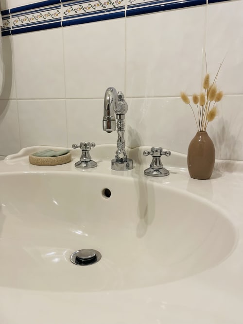 Élégant lavabo de la Maison Nolette B&B avec robinet chromé, porte-savon et vase décoratif de fleurs séchées