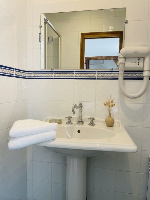 Salle de bains de la Maison Nolette B&B à Noyelles sur Mer avec lavabo sur colonne, miroir et douche