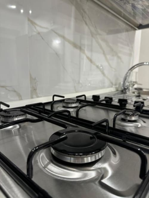 Moderno piano cottura a gas con bruciatori neri nella cucina dell'aparthotel Maison ì Room, Reggio di Calabria