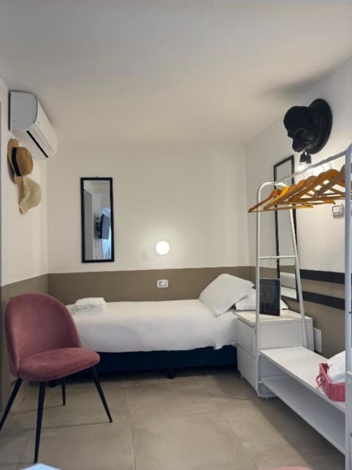 Camera moderna di Maison ì Room a Reggio di Calabria con letto singolo, letto a castello, poltrona bordeaux e arredamento minimalista