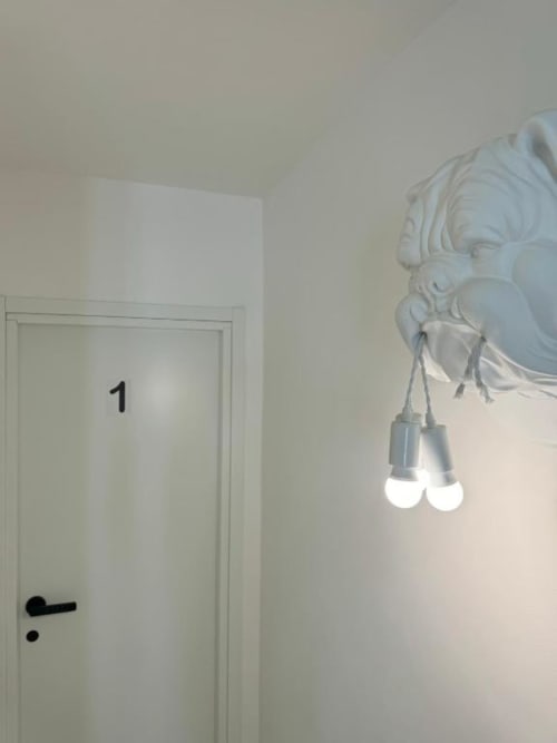 Corridoio dell'appartamento Maison ì con porta bianca numero 1 e elegante plafoniera decorativa