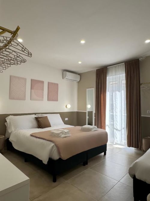 Camera da letto moderna in appartamento di Reggio di Calabria con letto matrimoniale, accesso al balcone e arredamento contemporaneo in tonalità beige e marrone