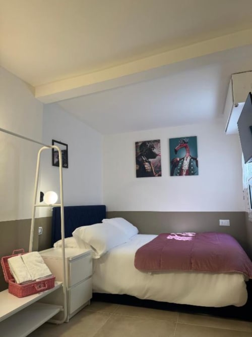Camera moderna nella Maison ì Room di Reggio di Calabria, con letto, lampada da tavolo, arte murale e arredamento contemporaneo
