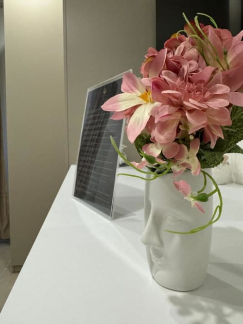 Fiori rosa in vaso bianco accanto a tablet presso Maison ì Room a Reggio Calabria