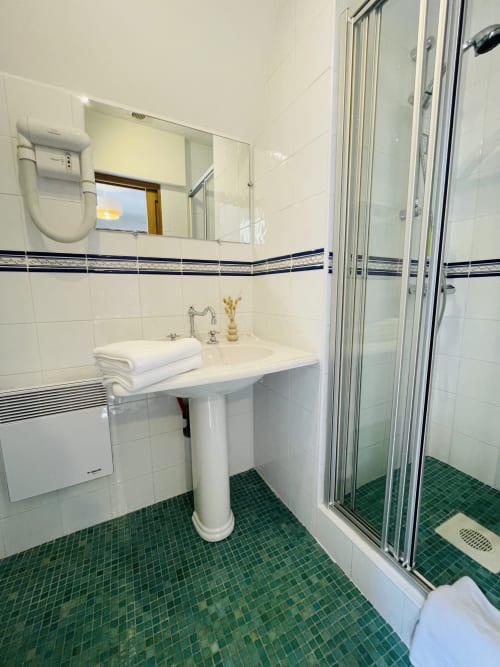 Salle de bain moderne de la maison d'hôtes Maison Nolette à Noyelles sur Mer avec lavabo sur colonne, cabine de douche et carrelage vert