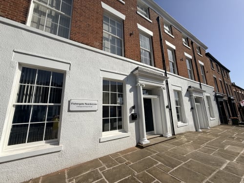 Fishergate Residences hotel exterior in Preston with white-rendered facade, columned entrance, and brick upper floors