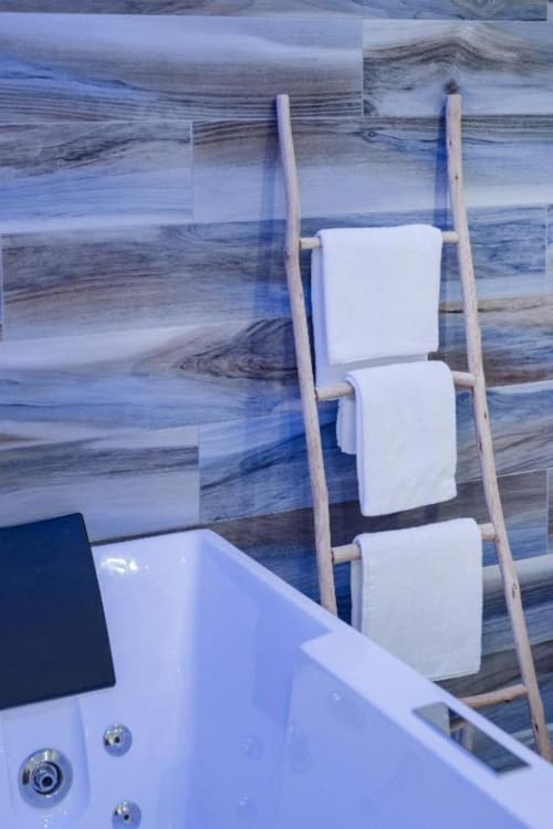 Scaletta portasciugamani in legno con biancheria bianca nella suite Il Poeta, Procida, con vista carta da parati oceano