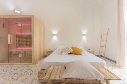 Suite moderna con sauna presso IL POETA BnB a Procida, con cabina sauna in legno, letto con cuscini e arredamento minimalista