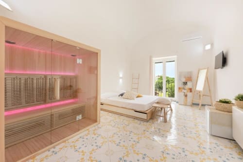 Ampia camera da letto con sauna presso Il Poeta B&B a Procida, con sauna in legno, letto e comfort moderni