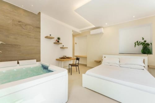 Suite deluxe con vasca idromassaggio presso IL POETA, Procida - letto, dettagli in legno, servizi moderni