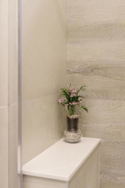 Mensola minimalista del bagno con fiori rosa in vaso in rilievo all'hotel IL POETA Procida