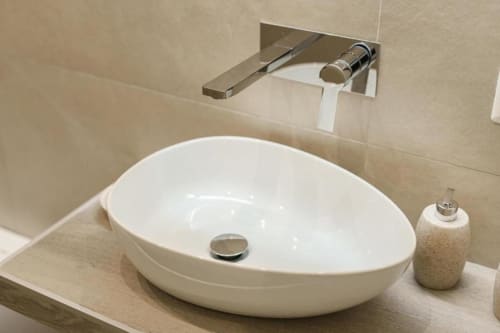 Elegante lavabo ovale bianco con rubinetto a parete cromato presso IL POETA, lussuosa struttura ricettiva a Procida, Italia