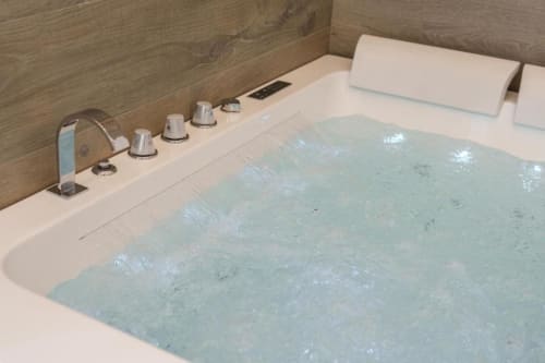Vasca idromassaggio lussuosa con getti d'acqua e servizi nella Deluxe Double Room di IL POETA, Procida