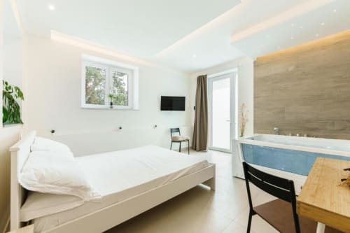 Spaziosa Camera Deluxe Doppia con vasca idromassaggio presso IL POETA, Procida - moderna camera da letto con letto, TV e zona bagno