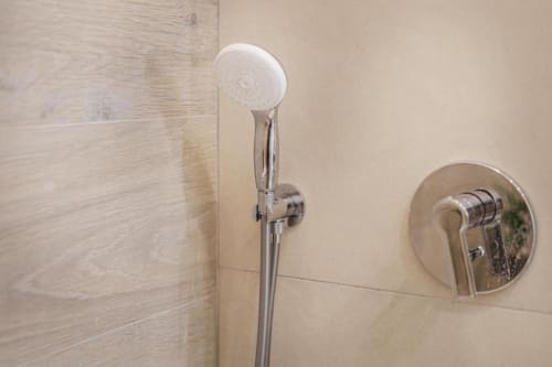 Soffione e rubinetteria cromati moderni nel bagno lusso di IL POETA con pareti piastrellate a Procida