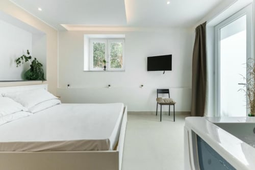 Camera moderna a IL POETA, Procida con biancheria bianca, TV a parete, finestra con vista sul giardino e design minimalista