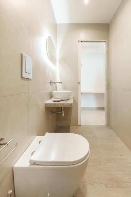 Bagno moderno a IL POETA, Procida con WC bianco, lavabo in ceramica, specchio riscaldato e pavimenti in legno
