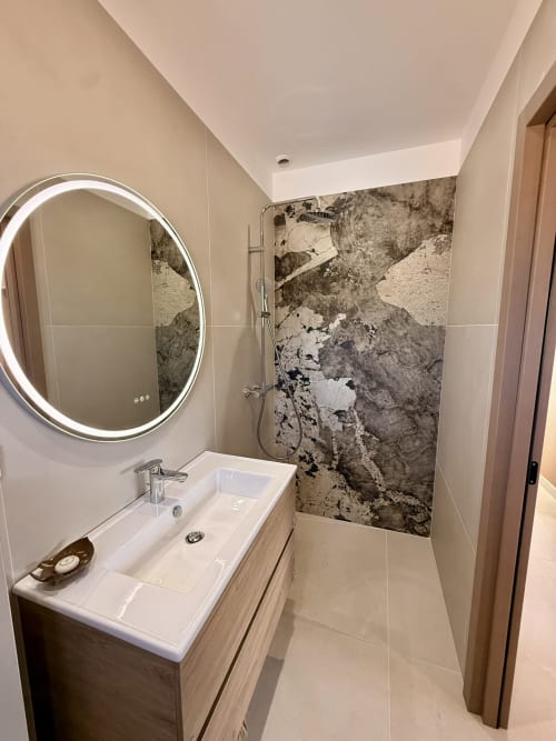 Salle de bain moderne avec miroir rétroéclairé, lavabo blanc et paroi de douche en marbre à la villa Figari