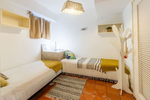 Dormitorio acogedor en Apartamento Sol & Sal, Albufeira con camas gemelas, paredes blancas, detalles amarillos y suelo de terracota.