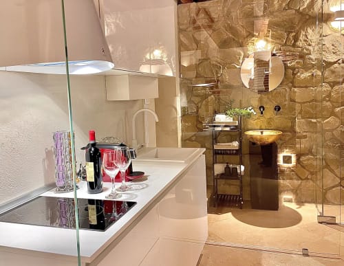 Luxury bathroom at STAYIN Verona with marble tile shower, wine glasses, and elegant fixtures