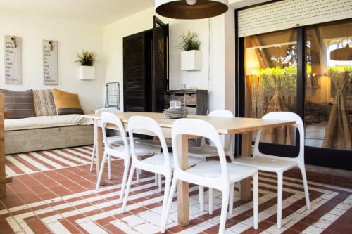 Comedor moderno con sillas blancas, mesa de madera y vistas al jardín en apartamento Urban Beach Rentals, Albufeira
