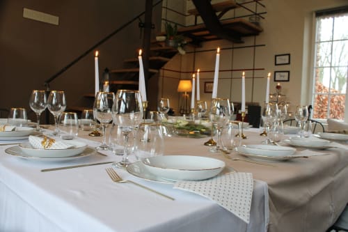 Table de salle à manger élégante dressée avec nappes blanches, bougies et verres au Domaine De La Ferme De Ribeaufontaine à Dorengt,