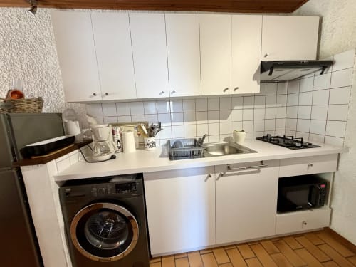 Cuisine moderne de l'appartement Colibri à Location Côte Landes, Mimizan, avec meubles blancs, cuisinière gaz et électroménagers