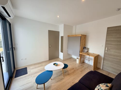 Séjour moderne à la Résidence CARPE DIEM à Lorgues avec parquet, sièges bleus et vue sur le jardin