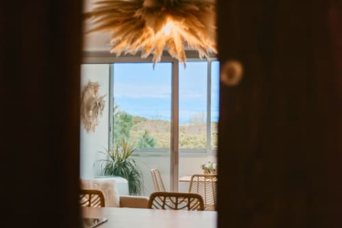 View through doorway to Sable & Pampas balcony overlooking hills, Carnon-Plage, France