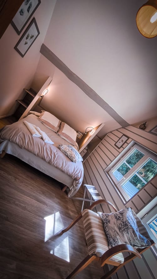 Chambre moderne et lumineuse au Clos du Buisson avec lit, parquet, vue sur le jardin et décoration contemporaine