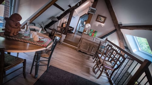 Suite spacieuse au grenier du Clos du Buisson avec poutres apparentes, coin repas, cuisine et vue sur jardin