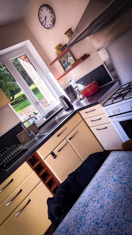 Cuisine du BnB Le Clos du Buisson avec meubles crème, électroménagers inox et vue sur le jardin