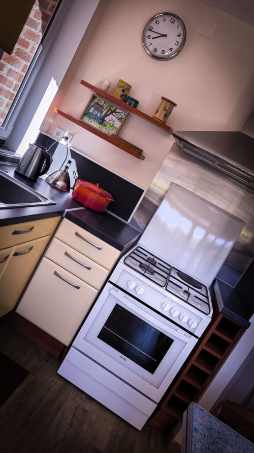 Cuisine du BnB Le Clos du Buisson à Saint Aubin sur Gaillon avec cuisinière, placards et horloge murale