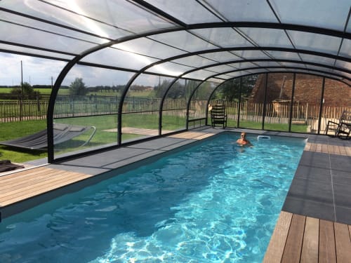 Piscine couverte chauffée aux eaux turquoise du Domaine De La Ferme De Ribeaufontaine, une maison d'hôtes en