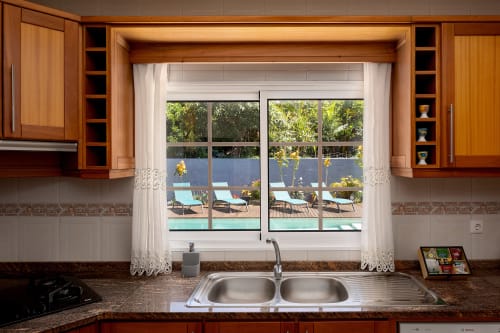 Cozinha moderna com pia dupla com vista para piscina e jardim da villa Paradise House em Calheta, Portugal