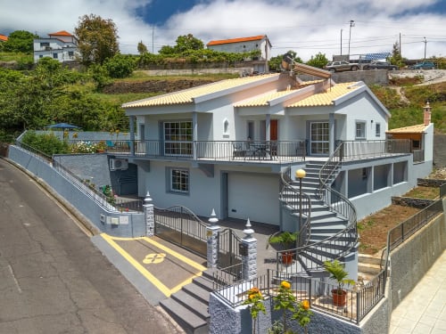 Villa moderna branca com telhado amarelo em Calheta, Portugal, com terraço, estacionamento e jardins paisagísticos