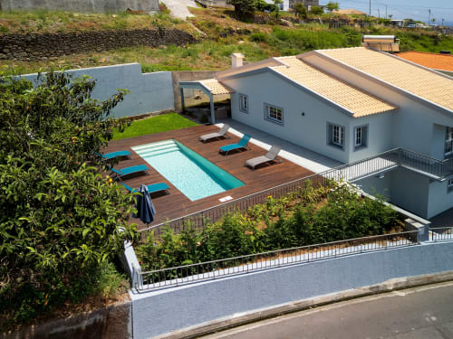 Villa Paradise House em Calheta com piscina, deck de madeira, espreguiçadeiras e arquitetura moderna branca