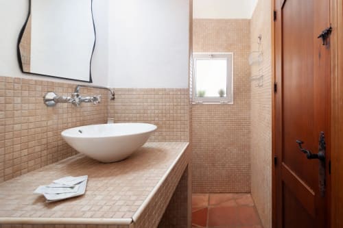 Modern bathroom sink with round white basin, beige tile walls, mirror and window at Apartamentos Turísticos Axarent in Málaga