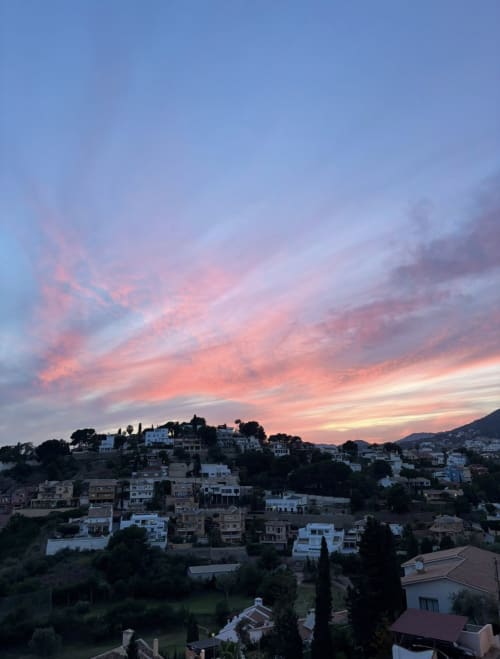 Sunset over hillside village of Málaga with Mediterranean architecture and mountain views from Apartamentos Turísticos
