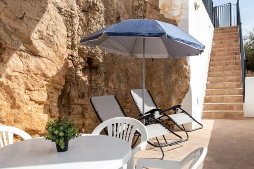 Shaded patio area with lounge chairs and umbrella at Apartamentos Turísticos Axarent in Málaga, Spain