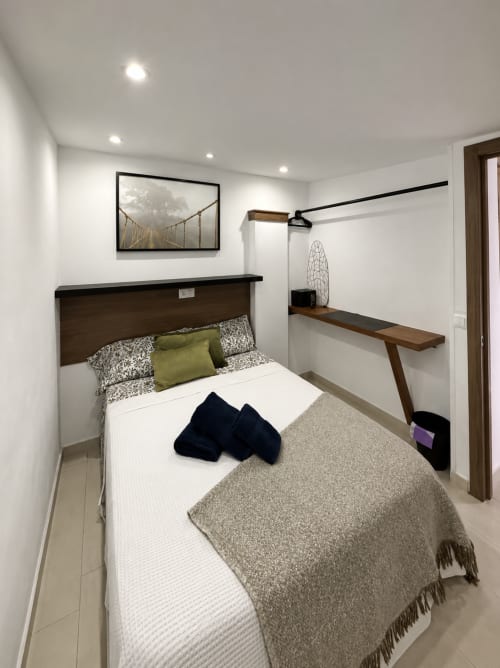 Modern bedroom at Apartamentos Turísticos Axarent with queen bed, desk, and white walls in Almayate Alto
