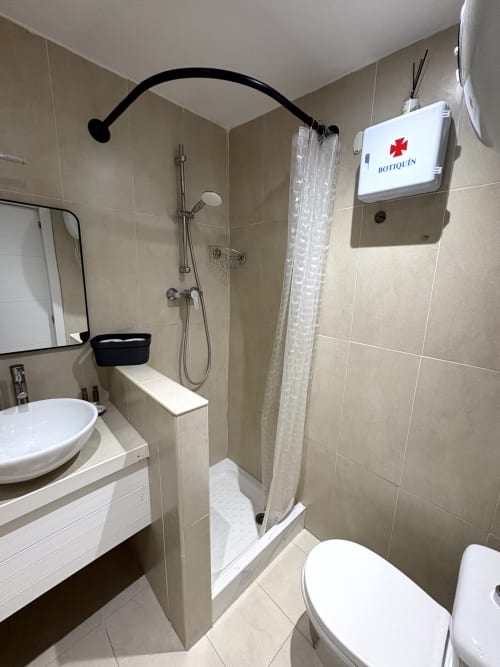 Modern bathroom in Almayate Alto apartment with shower, toilet, sink, and Botiquin first aid box