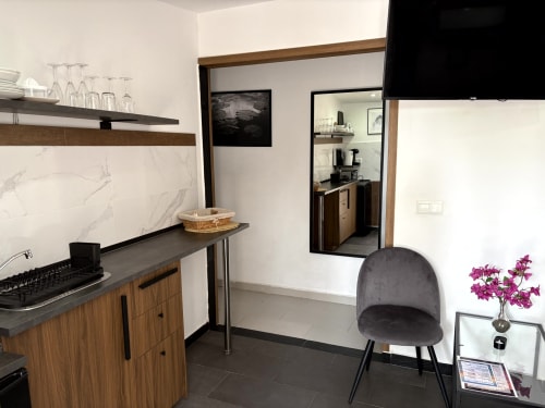 Modern kitchenette and living area in Apartamento 2 Playa Almayate, Almayate Alto, featuring wood cabinets, gray countertop,