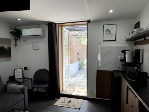 Modern studio apartment with kitchenette, seating area, and glass door opening to patio at Axarent, Almayate Alto