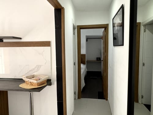 Bright hallway in Almayate Alto apartment with wooden-framed doorways, white walls, and access to bedroom and bathroom areas